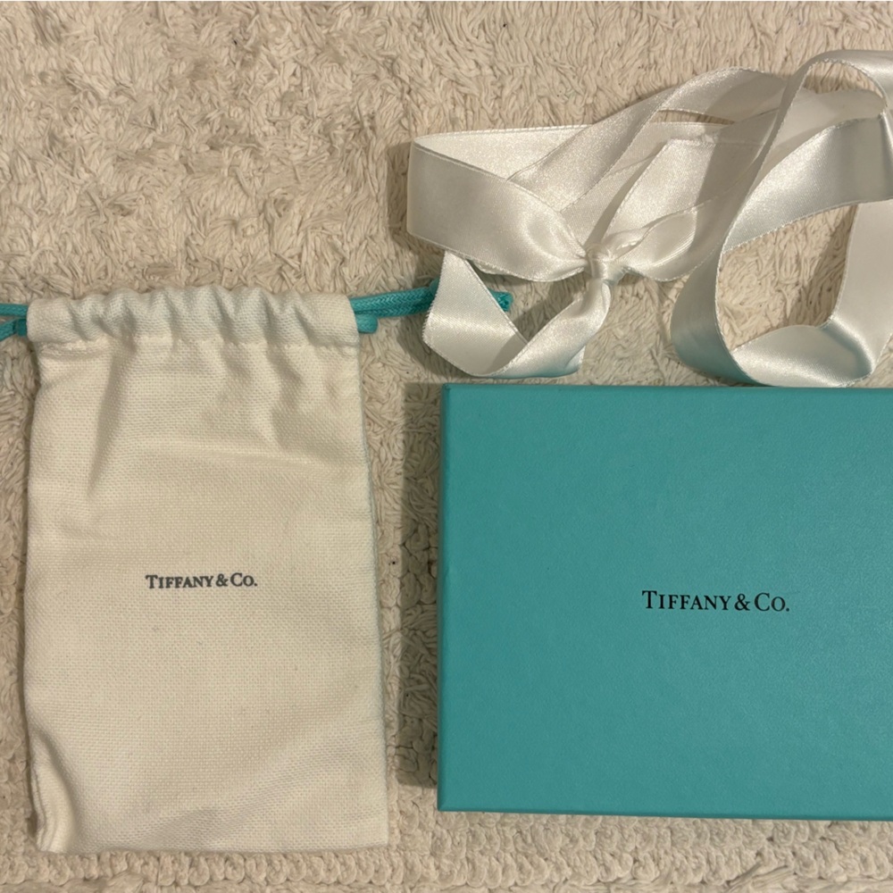 Tiffany & Co. white cloth bag, blue box, and original ribbon.